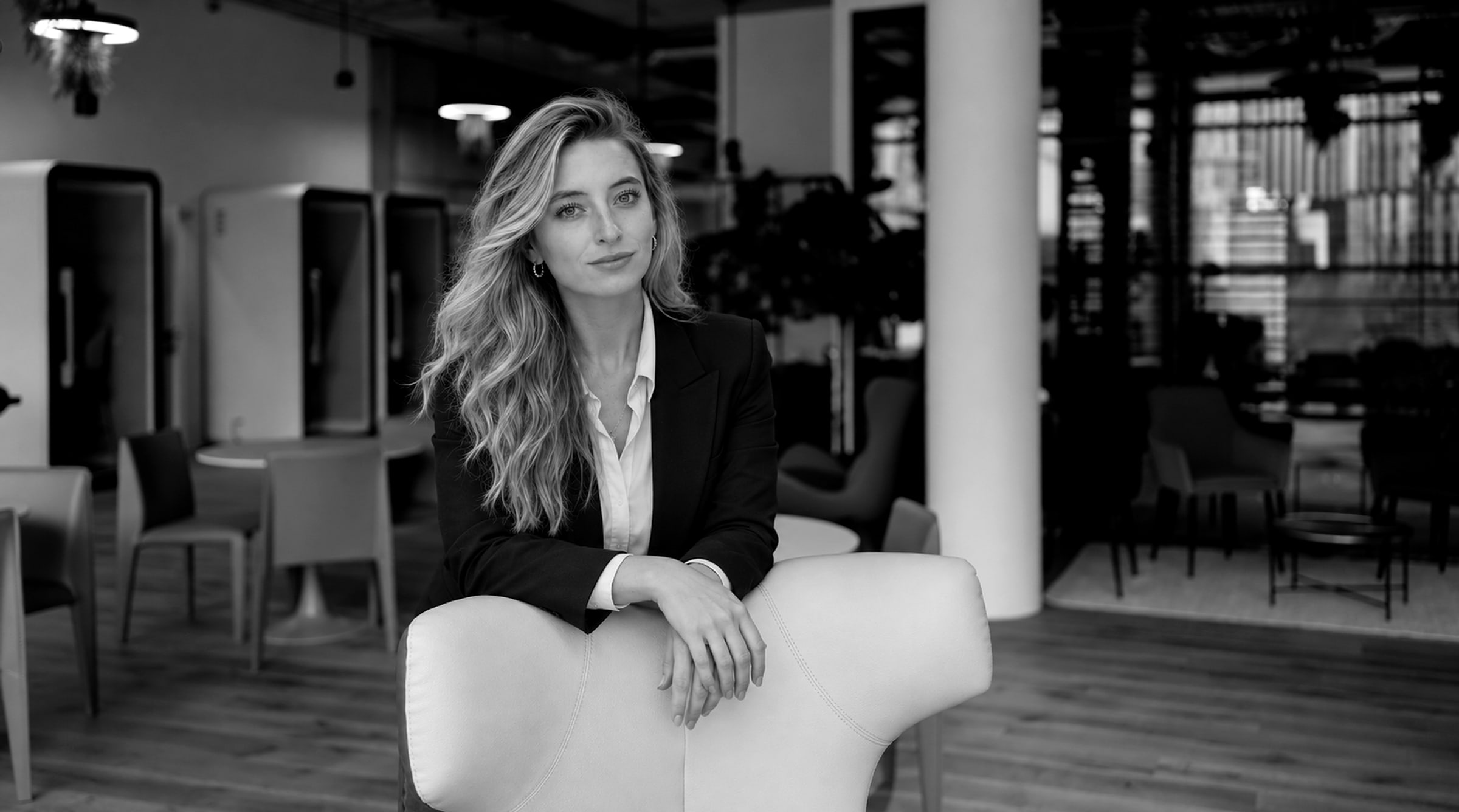 Lucie Krulichová, product and design leader in Prague, in a dark blazer in an open office, black and white portrait.